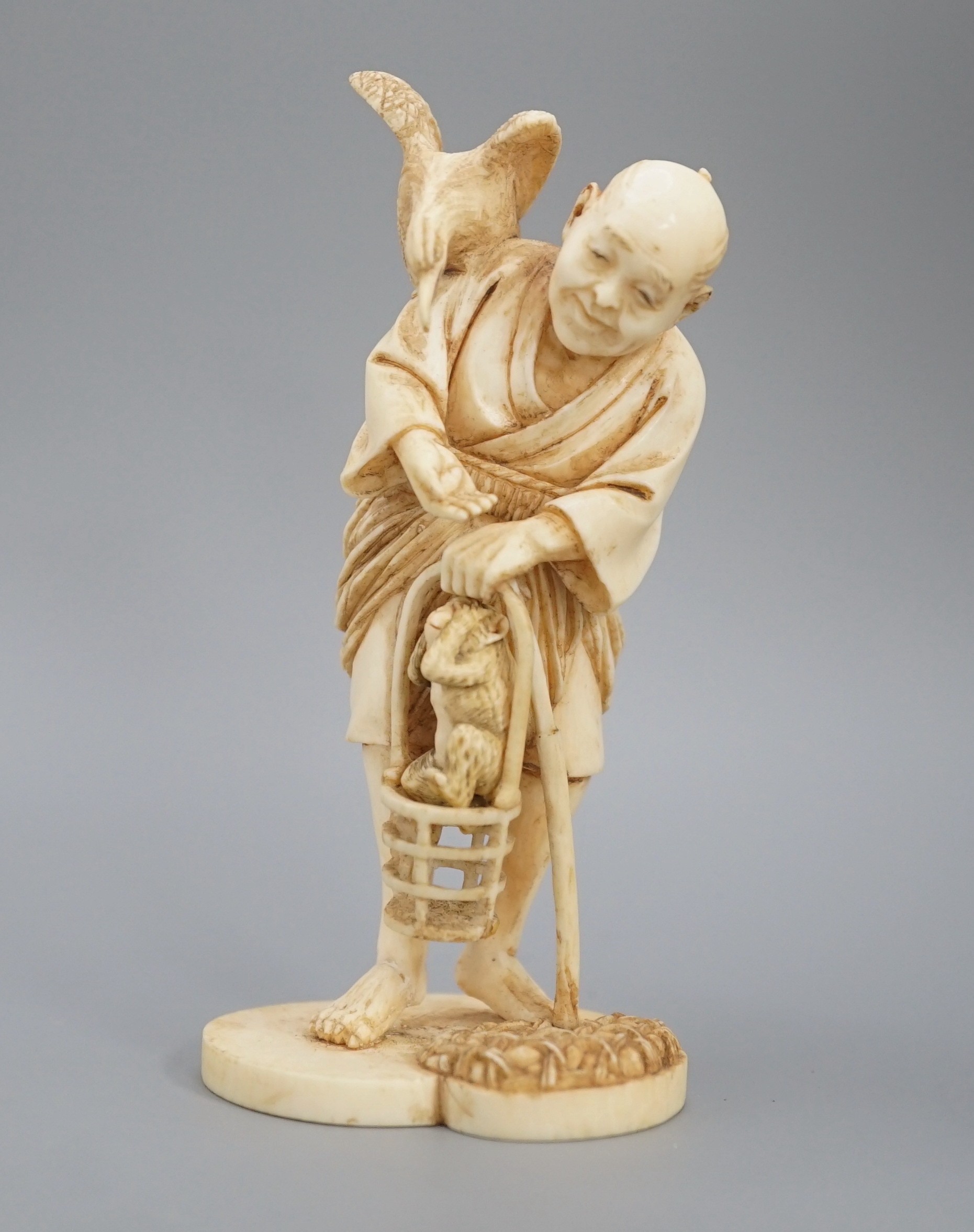 A Japanese ivory okimono of a cormorant fisherman, signed, Meiji period, 11cm and a small carving of a monkey